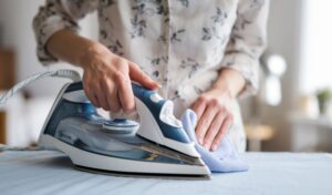 Osoba ฤisti ploฤu pegle mekom krpom