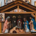Pravoslavne jaslice sa rođenjem Isusa Hrista u crkvi, okružene svetim figurama.