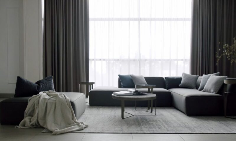 siva ugaona i fotelja u dnevnom boravku sa stolฤiฤem i knjigom na njemu