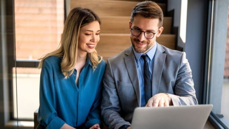 Dvoje poslovnih ljudi analiziraju sadržaj na laptopu u modernoj kancelariji