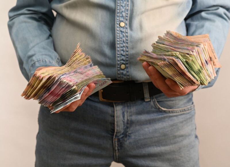 momak drži u rukama ogromnu količinu novca