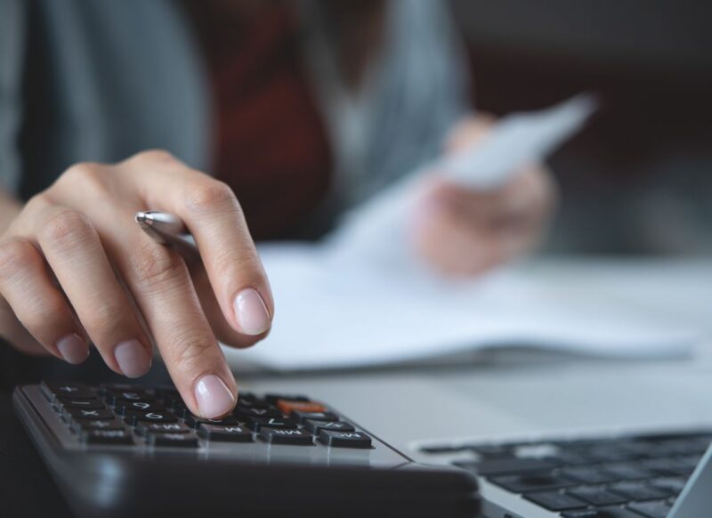 osoba obračunava mesečne troškove i koristi kalkulator