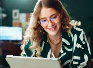 devojka koristi tablet i veselo se smeši