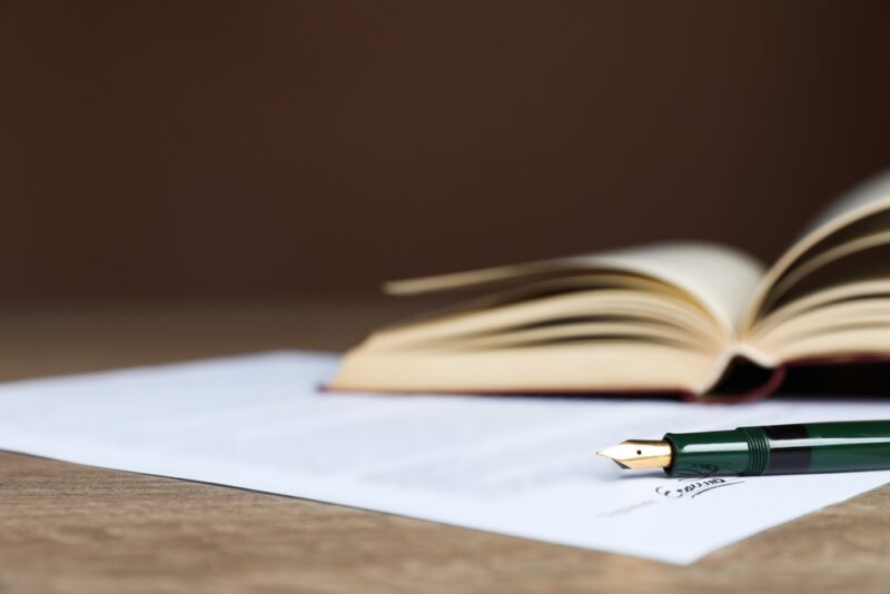 Dokument sa nalivperom i otvorenom knjigom kao simbol zvaničnih planova i uredbi