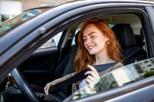 devojka vezuje pojas u automobilu