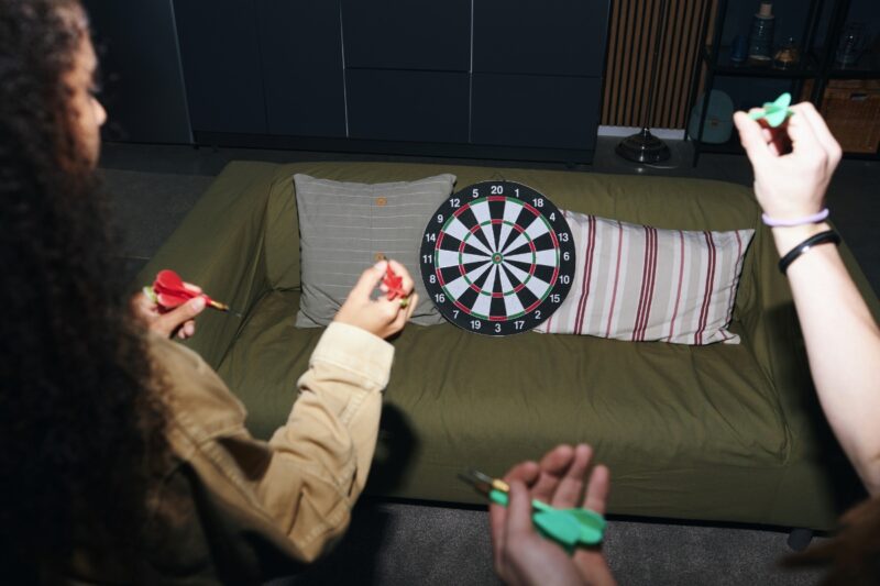 osobe igraju pikado kod kuće