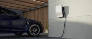 Električni automobil povezan na pametni zidni punjač u modernoj kućnoj garaži.